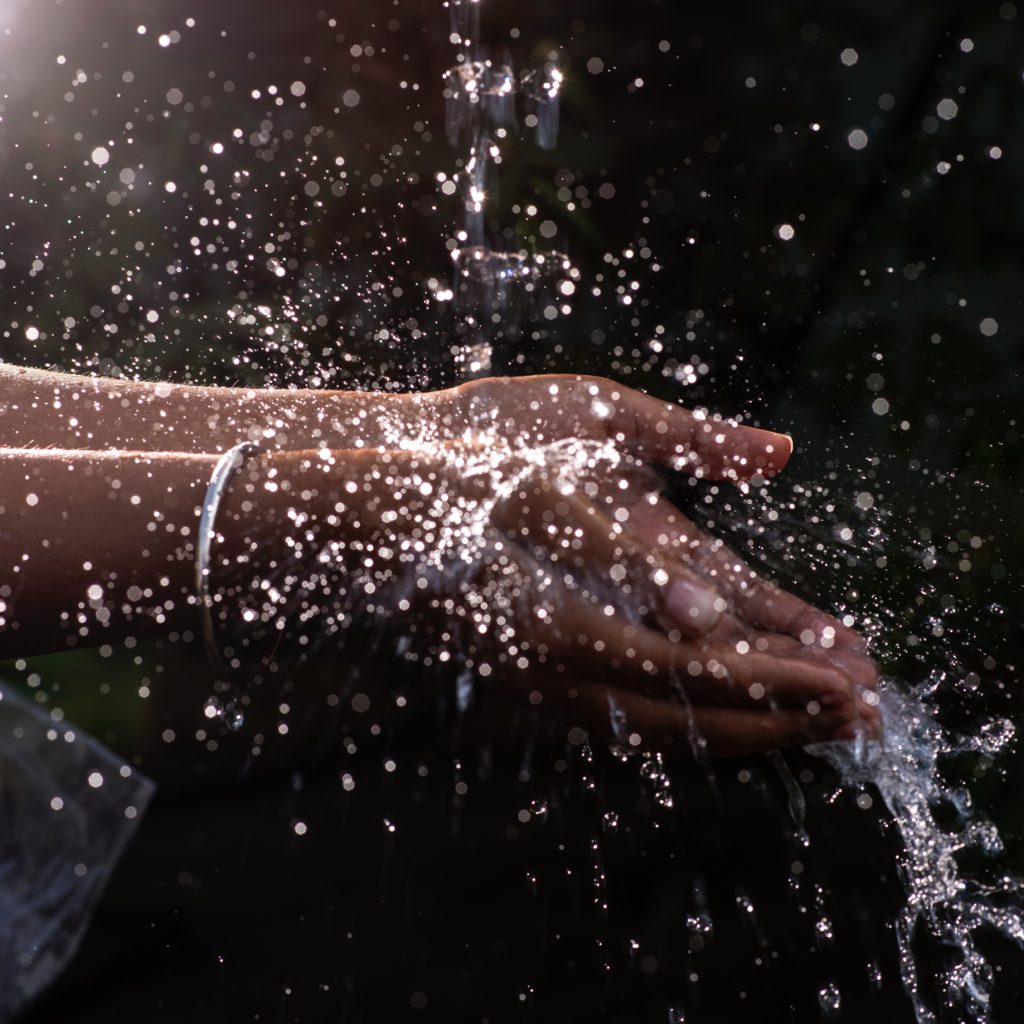 Eau qui coule sur des mains en gros plan